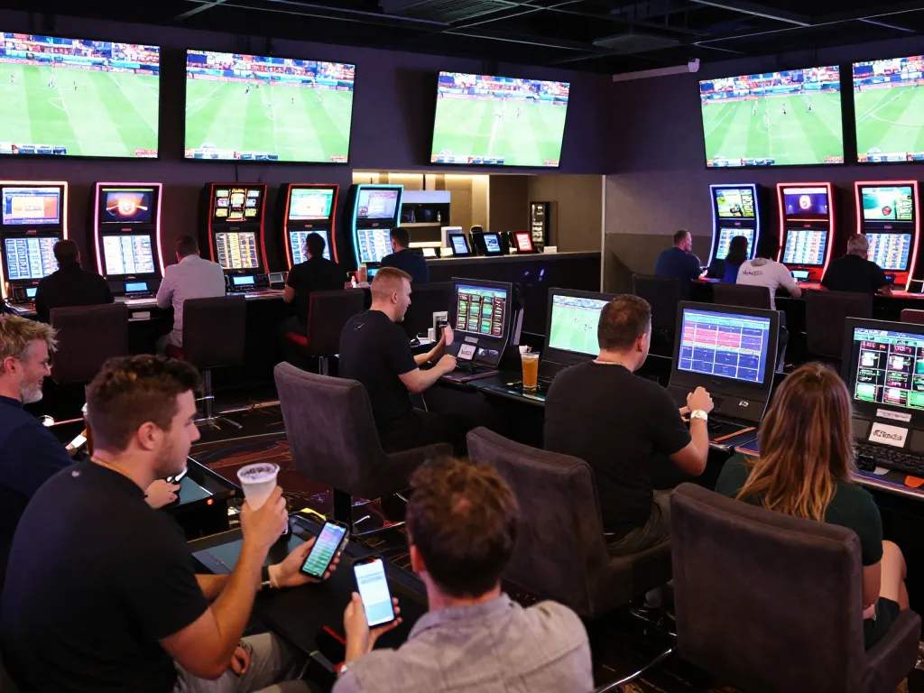 CM88 sports bettors cheering on live events in a modern casino lounge setting